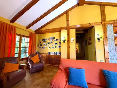 a living room with a red couch and blue pillows at Villa La Alegría in Conil de la Frontera