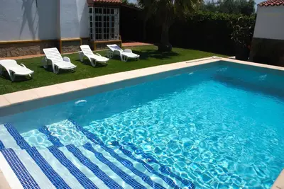 a swimming pool with lounge chairs and a swimming pool at Villa La Alegría in Conil de la Frontera