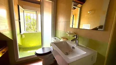 a bathroom with a sink and a toilet and a window at Villa El Cortijo Andaluz in Cádiz