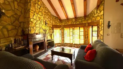 a living room with a couch and a stone wall at Villa El Cortijo Andaluz in Cádiz