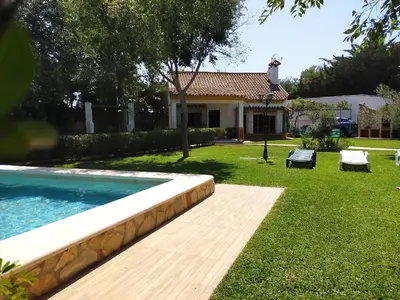 a backyard with a swimming pool and a house at Villa El Cortijo Andaluz in Cádiz