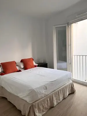 a bedroom with a large white bed with orange pillows at Casa El Puerto in El Puerto de Santa María