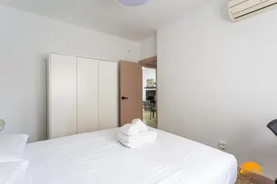 a bedroom with a white bed with towels on it at Teresa Uno by Cadiz Time in Cádiz
