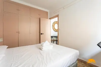 a bedroom with a white bed with towels on it at Teresa Uno by Cadiz Time in Cádiz