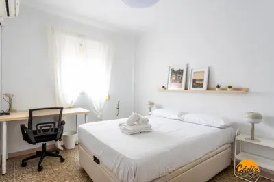 a bedroom with a bed with a desk and a chair at Teresa Uno by Cadiz Time in Cádiz
