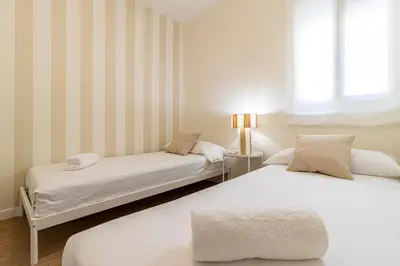 a bedroom with two beds and a window at Allo Apartments Merced Duplex Centro 2 habitaciones - 2 Baños in Jerez de la Frontera