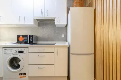 a kitchen with a refrigerator and a washing machine at Allo Apartments Merced Duplex Centro 2 habitaciones - 2 Baños in Jerez de la Frontera