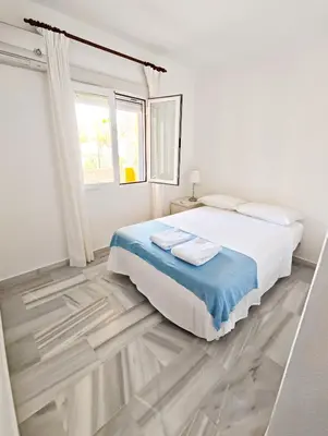 a white bedroom with a large bed and a window at Primera Linea Costa Ballena con Vista al Mar in Costa Ballena