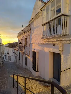 an old building with a balcony on a street at Casa Bombón in Medina Sidonia