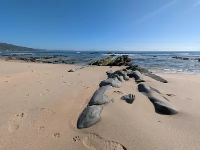 a group of rocks in the sand on a beach at Casa Bombón in Medina Sidonia