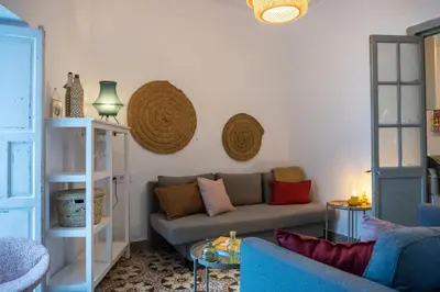 a living room with a couch and baskets on the wall at Casa Bombón in Medina Sidonia