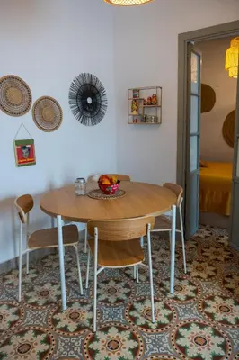 a dining room with a wooden table and chairs at Casa Bombón in Medina Sidonia