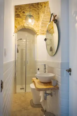 a bathroom with a sink and a toilet and a mirror at Casa Bombón in Medina Sidonia