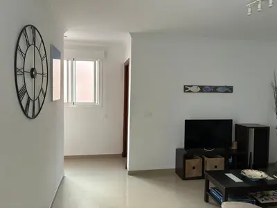 a living room with a large clock on the wall at Casa del Oratorio 1812 in Cádiz