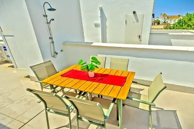a wooden table and chairs on a balcony at Jacuzzi & Pool House w Rooftop Terrace, Garden BBQ in El Puerto de Santa María