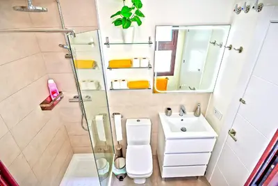 a bathroom with a shower and a toilet and a sink at Jacuzzi & Pool House w Rooftop Terrace, Garden BBQ in El Puerto de Santa María