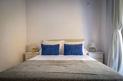 a bedroom with a bed with blue pillows at GINVA - Apartamento en pleno centro 1 in El Puerto de Santa María