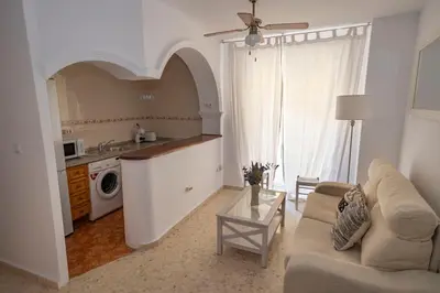 a living room with a couch and a kitchen at GINVA - Apartamento en pleno centro 1 in El Puerto de Santa María