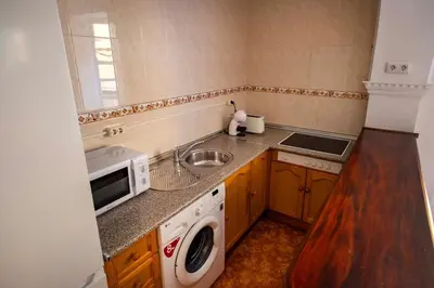 a small kitchen with a sink and a microwave at GINVA - Apartamento en pleno centro 1 in El Puerto de Santa María