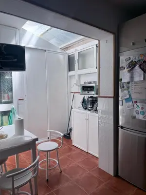a kitchen with a refrigerator and a table and chairs at Casa Coplas muy cerca de la playa in Sanlúcar de Barrameda