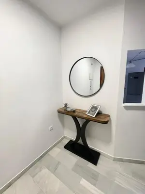 a mirror on a wall next to a table at Encantador y céntrico piso con garaje in Sanlúcar de Barrameda