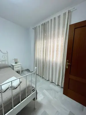 a bedroom with a bed and a large window at Encantador y céntrico piso con garaje in Sanlúcar de Barrameda