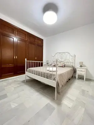 a bedroom with a white bed in a room at Encantador y céntrico piso con garaje in Sanlúcar de Barrameda
