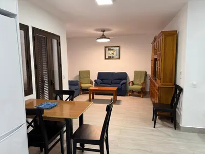 a living room with a table and chairs and a couch at Apartamento Completo en Chipiona in Chipiona