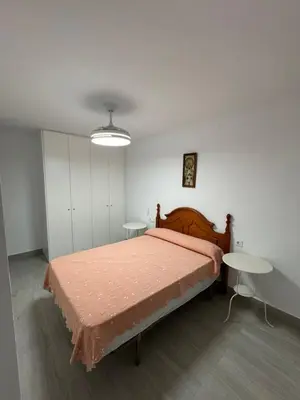 a bedroom with a bed and two tables at Apartamento Completo en Chipiona in Chipiona