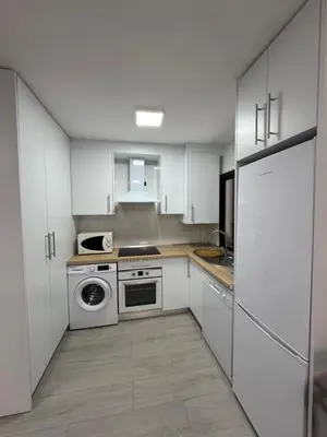 a kitchen with white cabinets and a stove top oven at Apartamento Completo en Chipiona in Chipiona