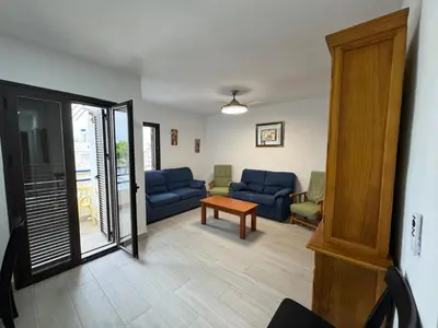 a living room with blue couches and a table at Apartamento Completo en Chipiona in Chipiona