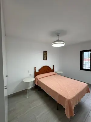 a bedroom with a bed and two tables in it at Apartamento Completo en Chipiona in Chipiona