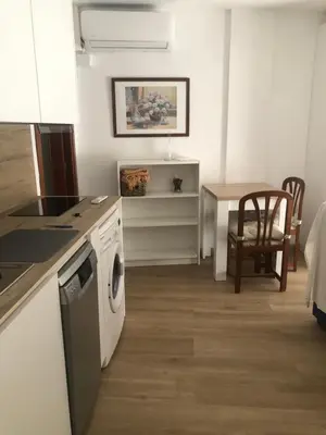 a kitchen and dining room with a table and a dishwasher at Puerto centro in El Puerto de Santa María