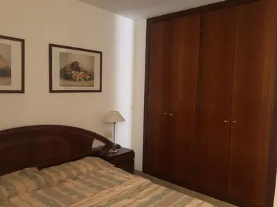 a bedroom with a bed and a wooden cabinet at Puerto centro in El Puerto de Santa María