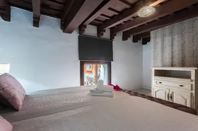 a bedroom with a large white bed with a window at Duplex Los Corceles Casa Palacio in Jerez de la Frontera