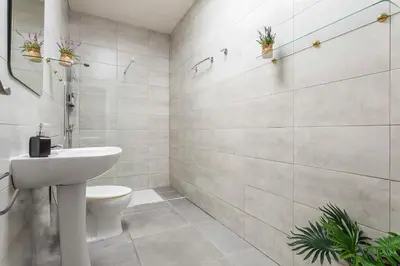 a white bathroom with a toilet and a sink at Duplex Los Corceles Casa Palacio in Jerez de la Frontera
