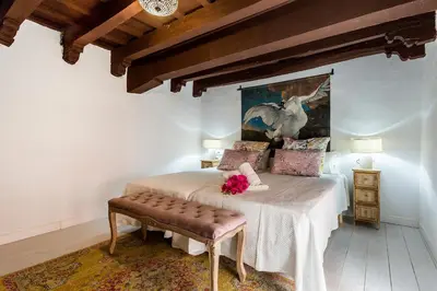 a bedroom with a bed and a painting on the wall at Duplex Los Corceles Casa Palacio in Jerez de la Frontera