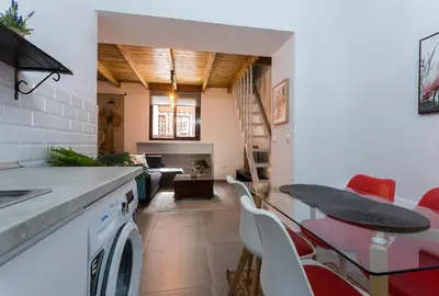 a kitchen and living room with a table and chairs at Duplex Los Corceles Casa Palacio in Jerez de la Frontera