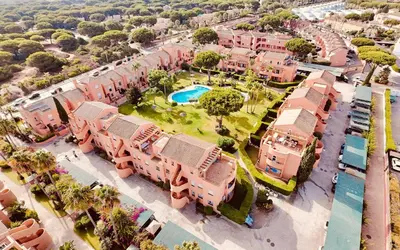 an overhead view of a city with pink buildings at Ático Jardín del Golf, Casa Alma in Chiclana de la Frontera