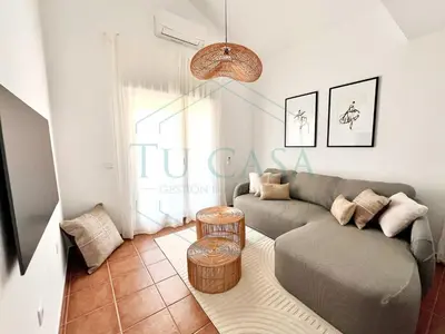 a living room with a couch and a table at Ático Jardín del Golf, Casa Alma in Chiclana de la Frontera