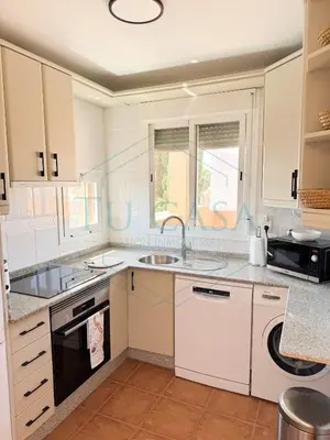 a white kitchen with a sink and a stove at Ático Jardín del Golf, Casa Alma in Chiclana de la Frontera