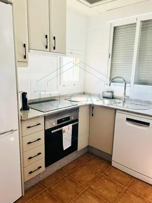 a kitchen with white cabinets and a sink and a dishwasher at Ático Jardín del Golf, Casa Alma in Chiclana de la Frontera
