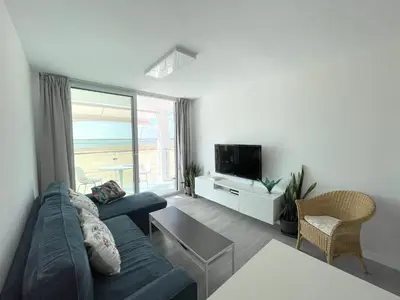 a living room with a couch and a tv at Apartamento en primera linea de playa in Sanlúcar de Barrameda