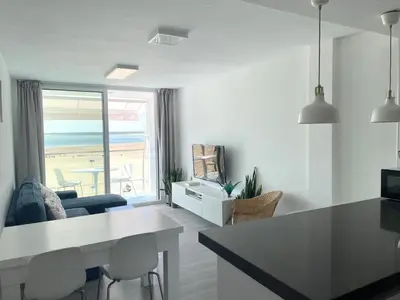 a white living room with a view of the beach at Apartamento en primera linea de playa in Sanlúcar de Barrameda