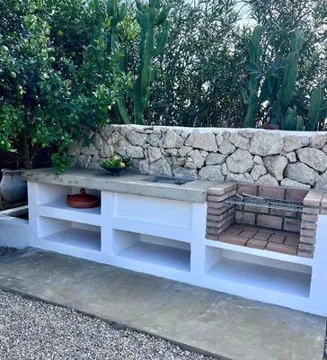 a bench sitting in front of a stone wall at Casa Chica Boutique in Sanlúcar de Barrameda