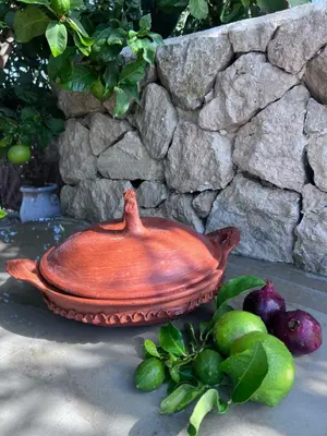 a red bowl sitting on the ground next to some fruit at Casa Chica Boutique in Sanlúcar de Barrameda