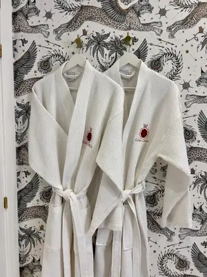 two white shirts are hanging on a wall at Casa Chica Boutique in Sanlúcar de Barrameda