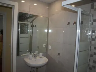 a bathroom with a sink and a shower with a mirror at Corales 6 in El Puerto de Santa María