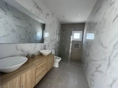 a bathroom with a sink and a toilet and a mirror at El Paraíso in Chiclana de la Frontera