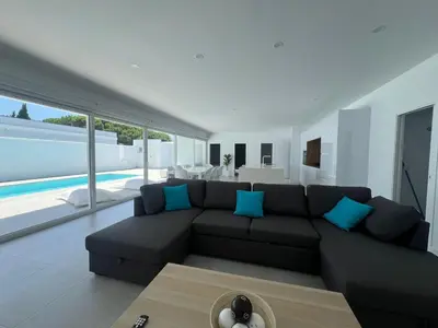 a living room with a black couch and blue pillows at El Paraíso in Chiclana de la Frontera